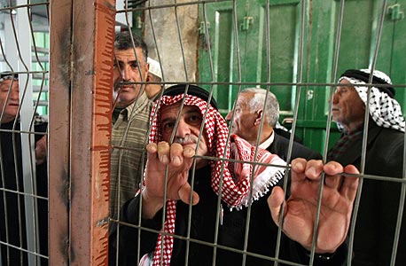 פועלים פלסטינים מחכים להיכנס לישראל במחסום בפאתי חברון
