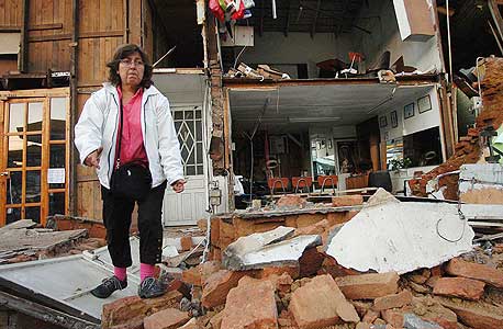 אשה ליד הריסות ביתה. "חברות הבנייה התרשלו בשמירה על התקן", צילום: אי פי אי
