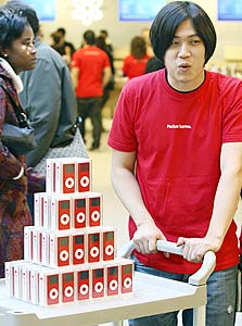 עובד אפל בחנות בניו יורק, עם האייפוד האדום שיוצר במיוחד לקמפיין RED 