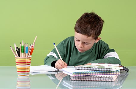 ילד מכין שיעורי בית. העיפרון והמחברת יחלפו מהעולם