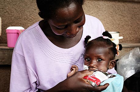 ילדה מבורקינה פאסו אוכלת פלאמפינאט. כל יחידה כזו מכילה כ-500 קלוריות