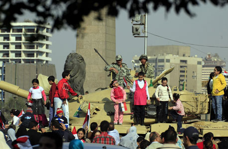 מפגינים מצטלמים למזכרת עם טנקים בכיכר תחריר. הצבא דואג קודם כל לעצמו, צילום: אי פי