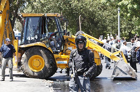 שוטר על רקע הטרקטור הפוגע בזירת האירוע, היום