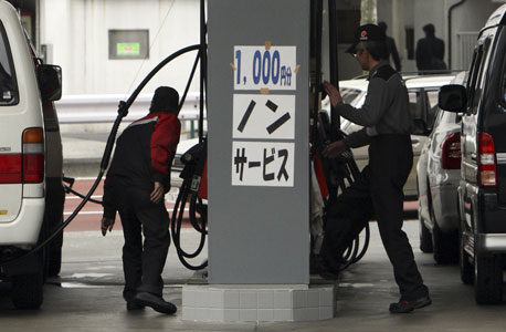עובדי תחנת דלק בטוקיו, צילום: בלומברג