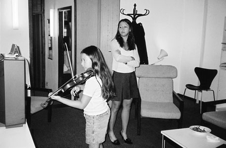 צ'ואה צופה בבתה סופיה מנגנת. "אם תיתן לילד בחירה  לשחק במחשב או להתאמן בנגינה, די ברור במה הוא יבחר" 