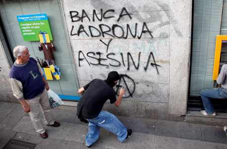 מגפינים מרססים גרפיטי נגד הבנקים במדריד, לפני שבועיים, צילום: רויטרס