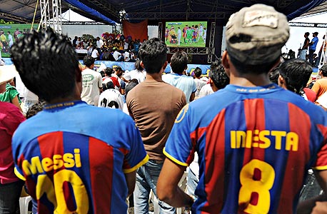 אוהדי ברצלונה עם חולצה של מסי ואינייסטה. במועדון רוצים שידברו על הקבוצה בכל העולם, בכל מקום, לפחות פעם ביום