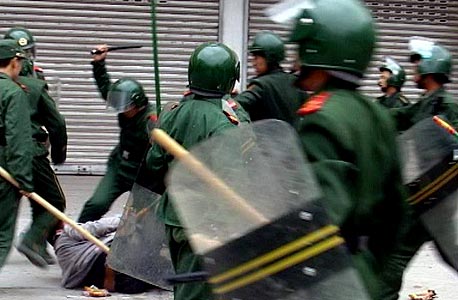 שוטרים סינים מכים מפגין בהפגנה בלונגאן