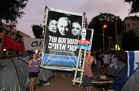 מפגינים מניפים שלטים הערב בת"א, צילום: אריאל שרוסטר