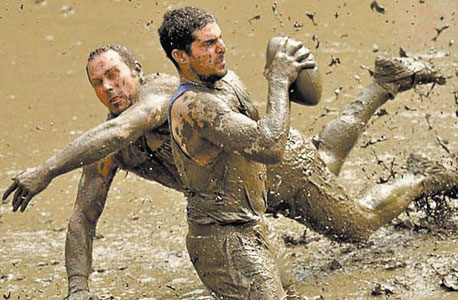 השחקנים בעיצומה של ההתגוששות בבוץ. משתפים גם נשים