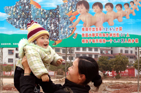 במרכז: כרזה סינית שמעודדת הולדת ילד אחד למשפחה, צילום: איי אף פי