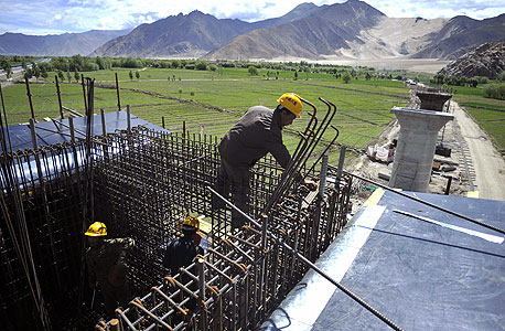 פועלים מקימים מעבר עילי לרכבות, בלהסה. קו הרכבת הגבוה בעולם