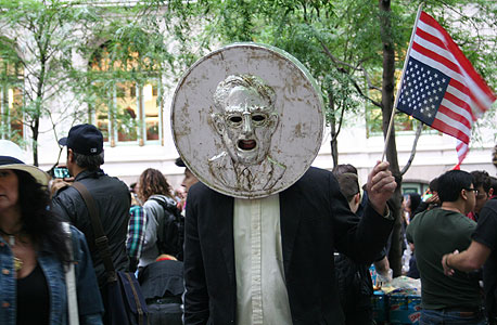 נח פישר כשמטבע ענק מסתיר את פרצופו