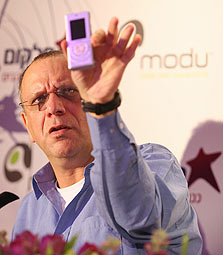 דב מורן מציג מכשיר סלולר של מודו. מכשיר טלפוני זעיר