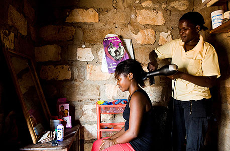 זמביה: ספרית מייעצת ללקוחה על שימוש בקונדום, בניסוי של מעבדת העוני שבו ספרים שימשו כסוכנים להפצת אמצעי מניעה בקהילה, צילום:  Gareth Bentley