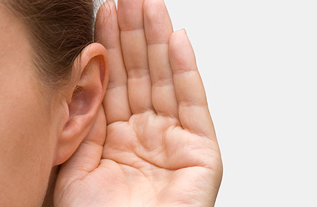 A person holding their hand to their ear. Photo: Shutterstock