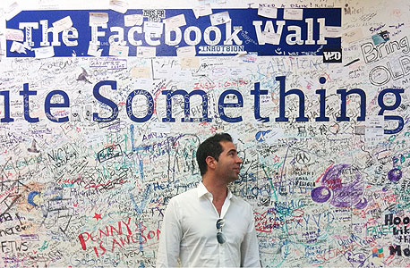 ערן גפן ליד קיר הגרפיטי של פייסבוק