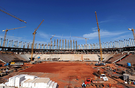 אצטדיון ברזיליה בבנייה. העלות המשוערת של האצטדיונים שולשה מאז שהוענקו לברזיל זכויות האירוח ב-2007. ההערכה הרשמית הנוכחית של 6.7 מיליארד ריאל היא גבוהה במידה ניכרת מ-1.4 מיליארד יורו שהוציאה גרמניה על 12 אצטדיונים עבור מונדיאל 2006, ופי 2 יותר מ-1.48 מיליארד דולר שהשקיעה דרום אפריקה על 10 אצטדיונים, רק לפני כשנתיים, צילום: איי אף פי 
