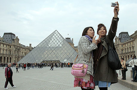 תיירות יפניות מנציחות את ההמתנה בתור ללובר בפריז. מק