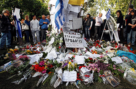 ביטויי אבל ספונטניים מול בניין הפרלמנט באתונה, במקום שבו התאבד רוקח בן 77