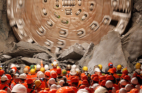 מכונת הכרייה פורצת את הקטע האחרון במנהרת גוטהרד. 58 ראשי חפירה שקודחים בלחץ של 26 טונות, צילום: רויטרס