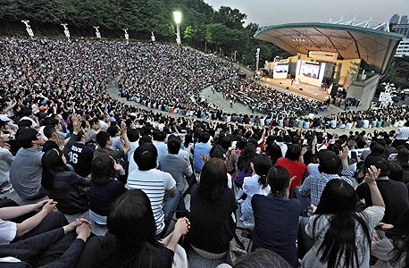 סנדל מדבר בפני 14 אלף איש באצטדיון בדרום קוריאה. מאז 1980 הוא מעביר את הקורס הפופולרי באוניברסיטת הרווארד, המכונה בפשטות "צדק", צילום: Kiku Adatto