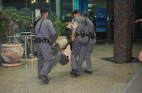שוטרים עוצרים מפגין