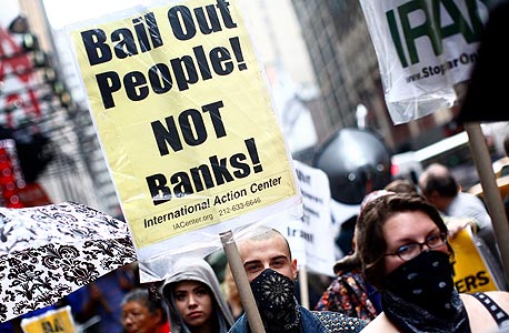 הפגנה בניו יורק נגד תוכנית החילוץ של הבנקים, 2008. "החילוץ בוצע בחוסר הוגנות עמוק. אלה שגרמו למשבר זכו לתגמול נדיב, ולוקחי המשכנתאות, מעמד הביניים, זכו להתעלמות"