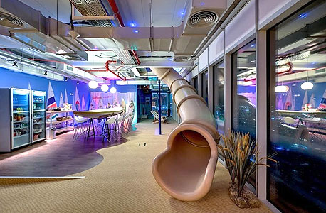 A slide leading to a furnished dining area at Google