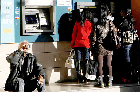 אנשים בתור למשיכת כספם מהבנק בקפריסין