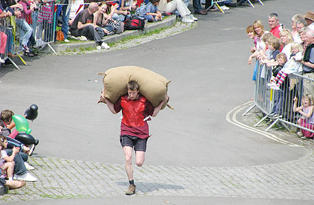 מתמודד במירוץ בעיירה Tetbury. שלושים ק"ג על הגב והרבה בירה בבטן מתמודד במירוץ בעיירה Tetbury. שלושים ק"ג על הגב והרבה בירה בבטן