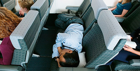 נוסע מנמנם על גבי המושבים במטוס. גם הטייסים "מנקרים"