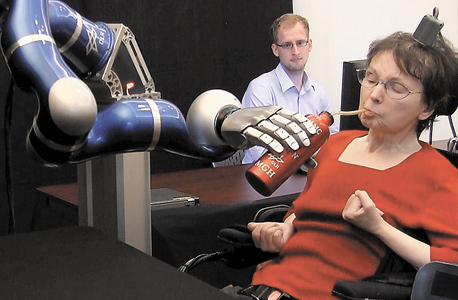 קאתי האצ'ינסון מפעילה זרוע רובוטית בכוח מחשבתה. דונהיו: "רוצה לשקם איברים ששותקו"