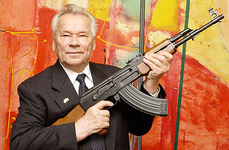 מיכאיל קלצ'ניקוב עם הרובה הנושא את שמו