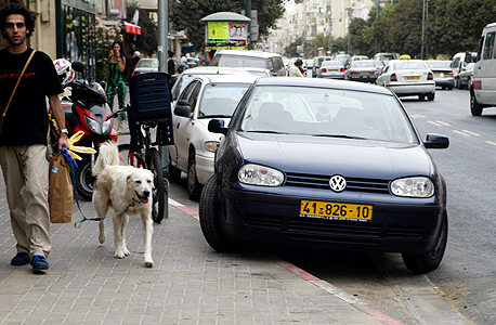 מכונית חונה באדום לבן בתל אביב. סימון יצירתי בחלק מהרחובות