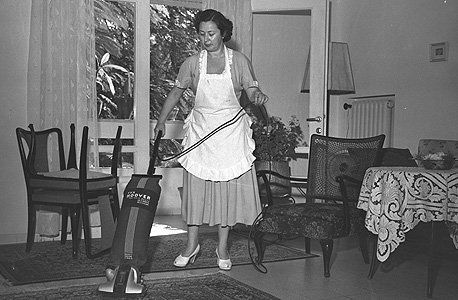 אשה מנקה סלון בתל אביב, 1949. רהיטים קלים מחומרים זולים שאפשר לנייד בקלות 