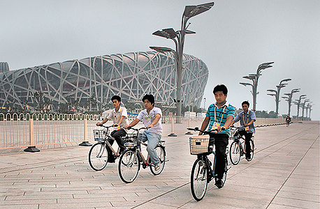 בלי זיהום. רוכבי אופניים סמוך לאצטדיון האולימפי בבייג'ינג