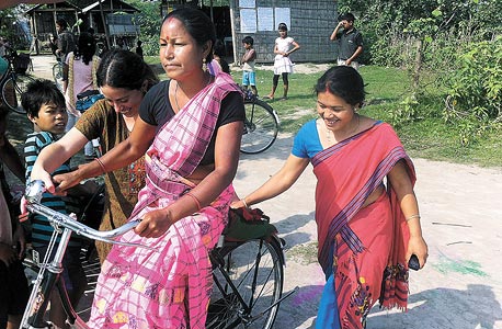 תושבת האי לומדת לרכוב על אופניים. במקום ללכת שעות ברגל לכפר השכן