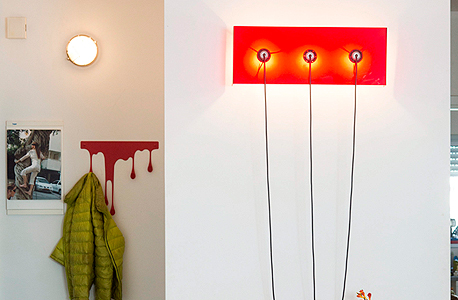 שידה אדומה מאיקאה ומעליה גוף תאורה שהורכב על ידי ליזר , צילום: תומי הרפז