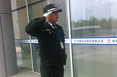 שומר בכניסה למפעל ברייט דיירי בשנגחאי 