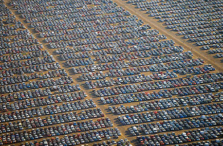 אלפי מכוניות מאוחסנות בחניון ענק תחת השמש הקופחת של ספרד