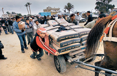 פלסטיני דוחף עגלה עמוסה במלט שהועבר ממצרים לרצועה