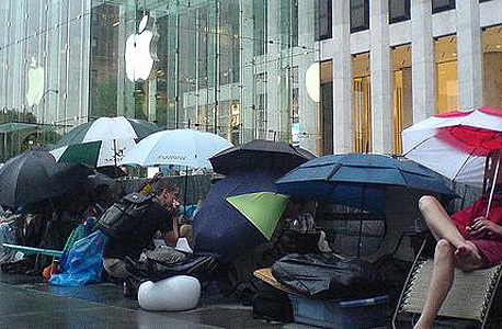 מעריצי אפל מחכים בגשם כדי לקנות טלפון