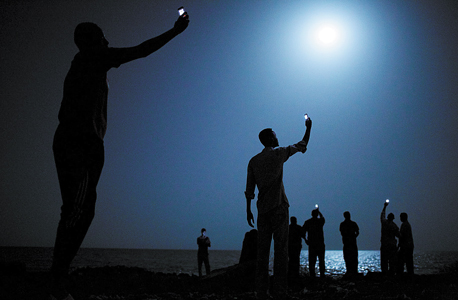 התצלום הזוכה של ג'ון סטיינמאייר. פליטים בג'יבוטי מחפשים קליטה סלולרית