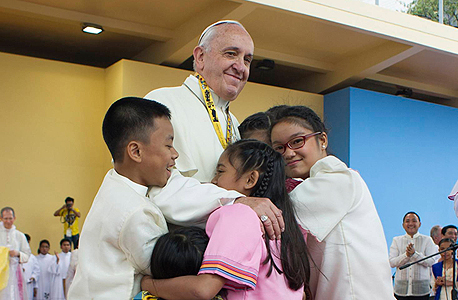 האפיפיור פרנציסקוס מחבק ילדים בביקורו השבוע בפיליפינים
