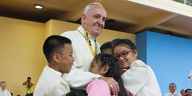 האפיפיור פרנציסקוס מחבק ילדים בביקורו השבוע בפיליפינים, צילום: בלומברג