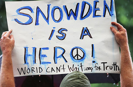 כרזה ועליה המשפט: "סנודן הוא גיבור", בהפגנה נגד ריגול ממשלתי