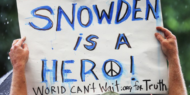 כרזה ועליה המשפט: "סנודן הוא גיבור", בהפגנה נגד ריגול ממשלתי