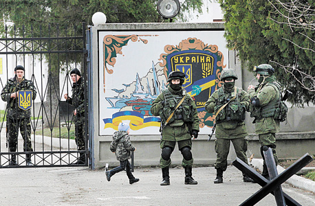 חיילים רוסים (מקדימה) ואוקראינים (מאחורי השער) באוקראינה, במאי. "כשפוטין רוצה להיות פופולרי הוא יוצא למלחמה"