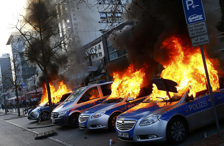 רכבי משטרה עולים באש בהפגנה, צילום: מוריס אסולין